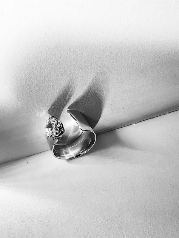 Hõbedane sõrmus mustvalgel detailfotol
